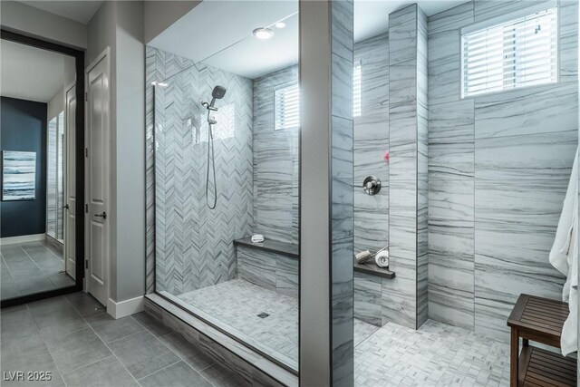 bathroom with tile patterned flooring and a tile shower