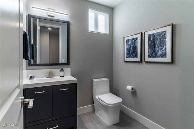 half bath with vanity, toilet, and baseboards