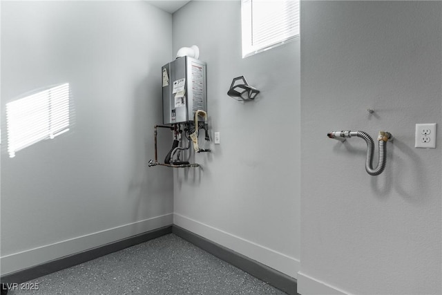 interior space featuring speckled floor, tankless water heater, and baseboards