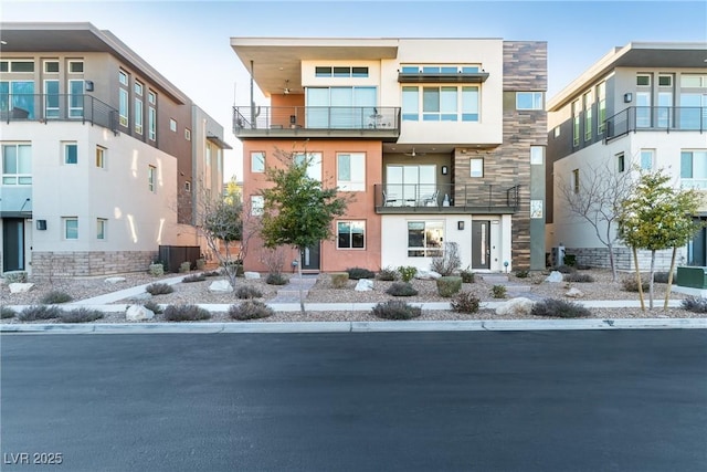 view of front facade featuring stone siding and stucco siding