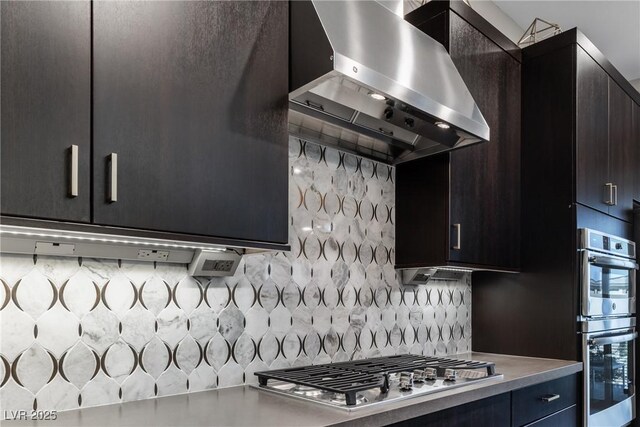 kitchen featuring appliances with stainless steel finishes, exhaust hood, and decorative backsplash