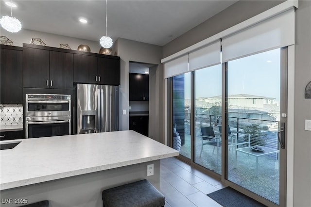 kitchen featuring appliances with stainless steel finishes, a sink, and decorative light fixtures