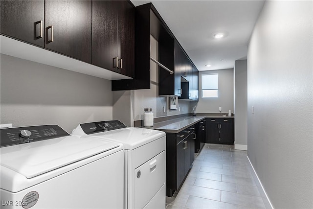 laundry area with light tile patterned floors, cabinets, and washing machine and clothes dryer