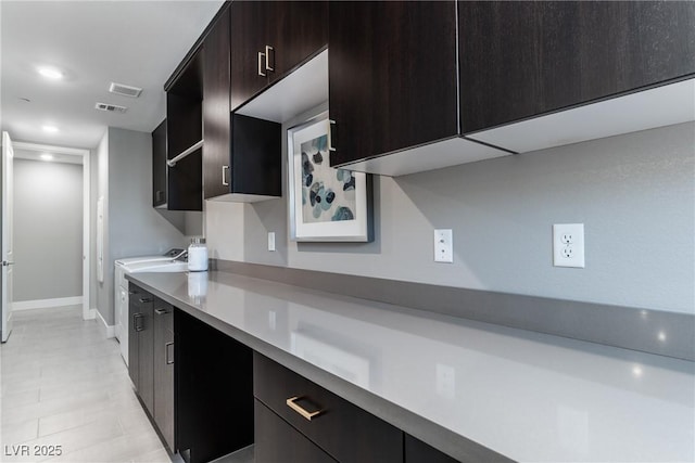 kitchen with washer / clothes dryer and dark brown cabinets