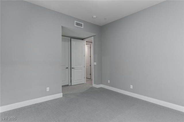 empty room featuring baseboards, visible vents, and carpet flooring