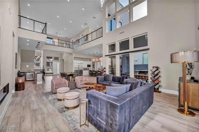 living room featuring a towering ceiling and light hardwood / wood-style floors