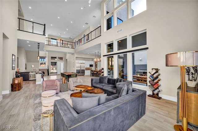 living room with light hardwood / wood-style floors and a high ceiling