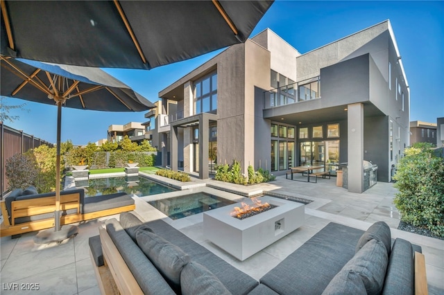 exterior space featuring an outdoor living space with a fire pit and an in ground hot tub