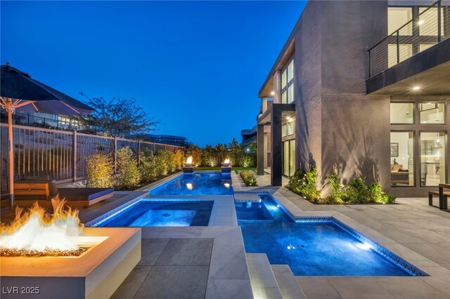 view of pool featuring a fire pit, a patio, and an in ground hot tub