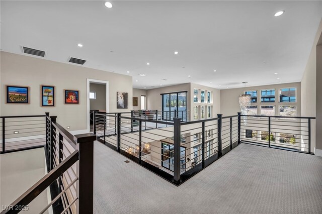 hallway featuring plenty of natural light and light carpet