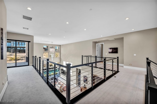 hallway featuring carpet flooring and an inviting chandelier