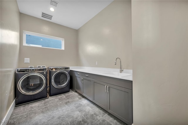 laundry area with cabinets, sink, and washer and clothes dryer