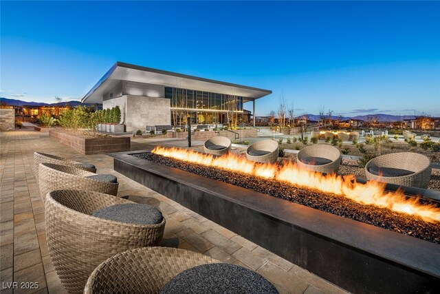 patio terrace at dusk with a mountain view and an outdoor fire pit