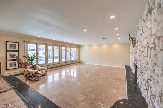 unfurnished living room with recessed lighting and baseboards