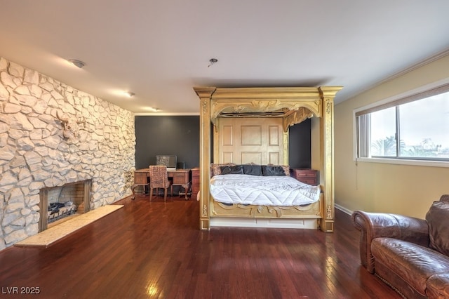 bedroom with a fireplace, dark wood-type flooring, and crown molding