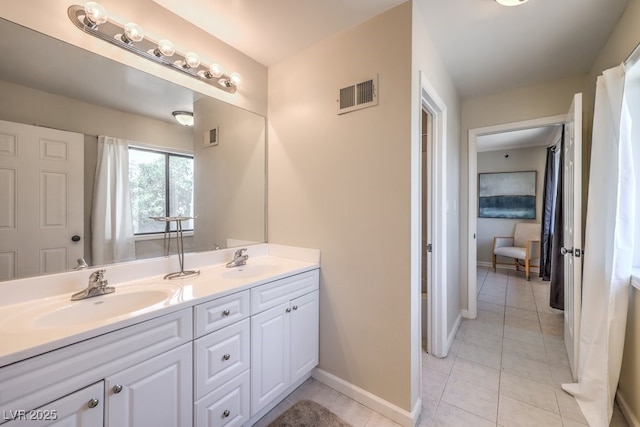 full bath featuring double vanity, tile patterned flooring, visible vents, and a sink