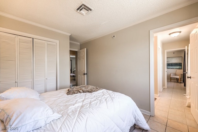 bedroom with light tile patterned floors, ornamental molding, a textured ceiling, and visible vents