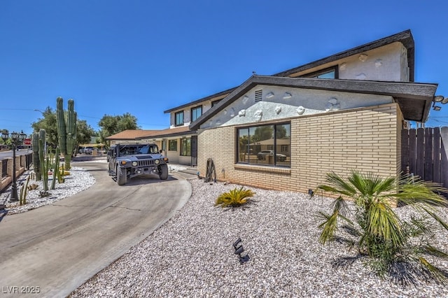 view of front of property with brick siding and fence