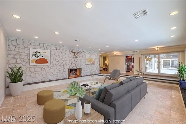 living room with a fireplace, visible vents, and recessed lighting