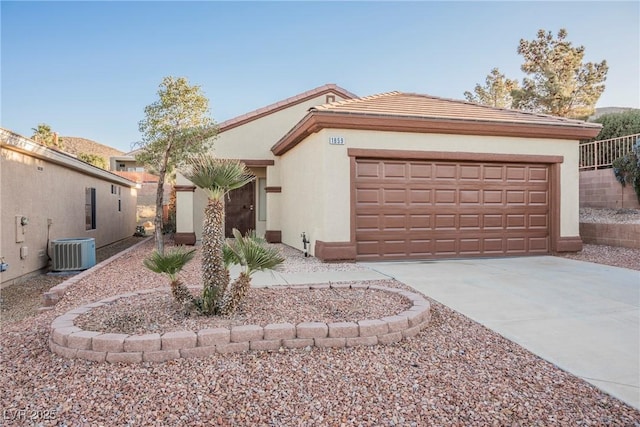 view of front of home with a garage and central AC