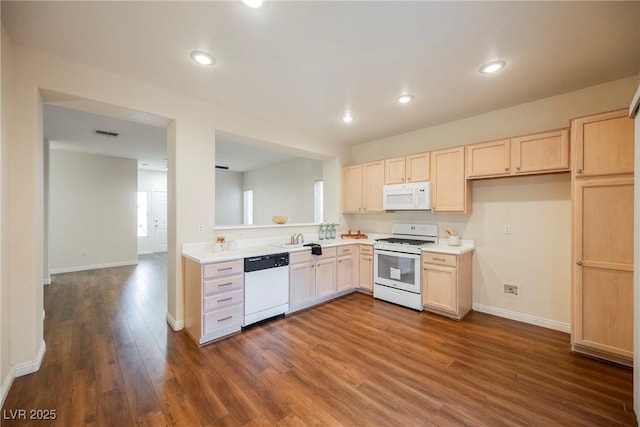 kitchen with white appliances, dark hardwood / wood-style flooring, light brown cabinetry, and sink