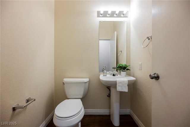 bathroom with hardwood / wood-style floors and toilet