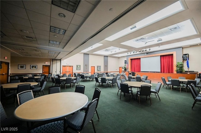 carpeted dining space featuring a drop ceiling