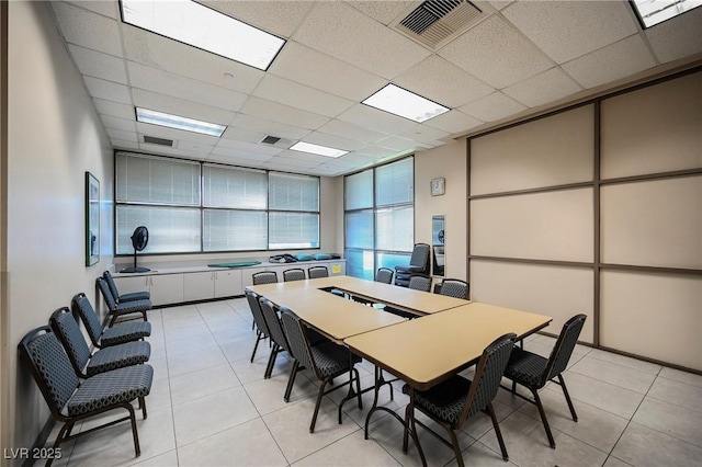 tiled dining space with a paneled ceiling