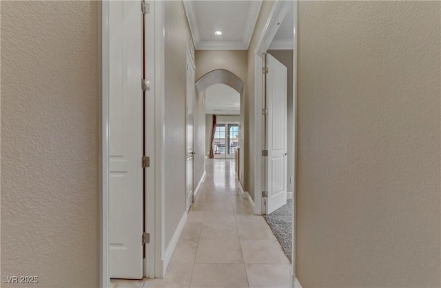 hall featuring light tile patterned floors and ornamental molding