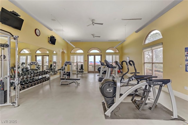 exercise room with plenty of natural light and a high ceiling