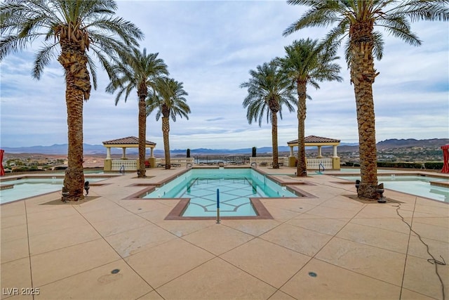 view of swimming pool with a mountain view, a gazebo, and a patio