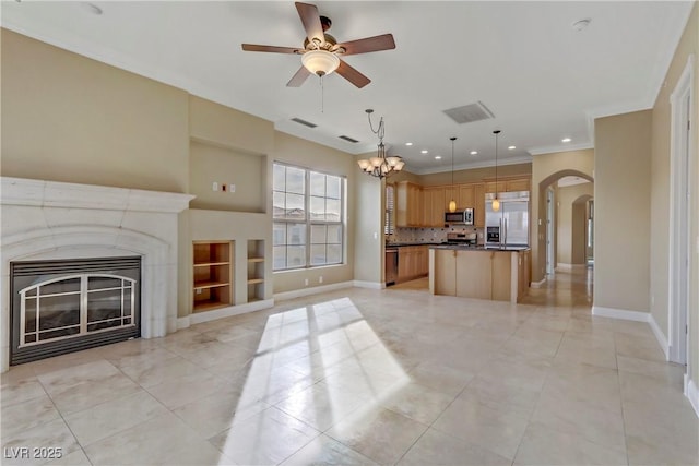 unfurnished living room featuring light tile patterned flooring, ornamental molding, and ceiling fan with notable chandelier