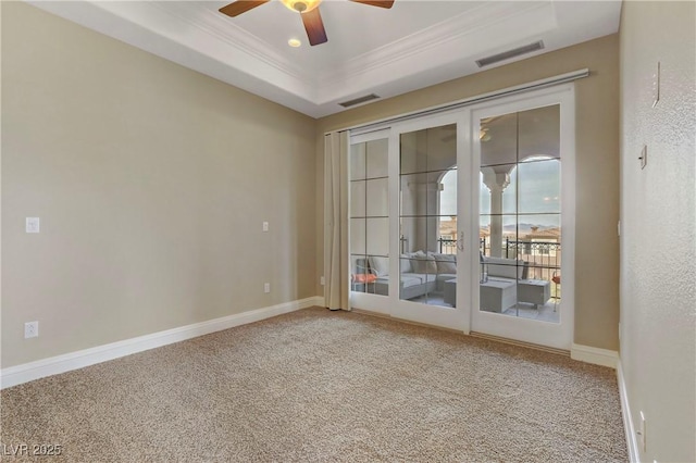 carpeted empty room featuring french doors, crown molding, ceiling fan, and a tray ceiling