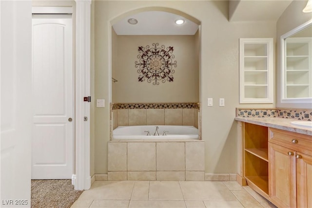 bathroom featuring vanity, tile patterned flooring, and tiled tub