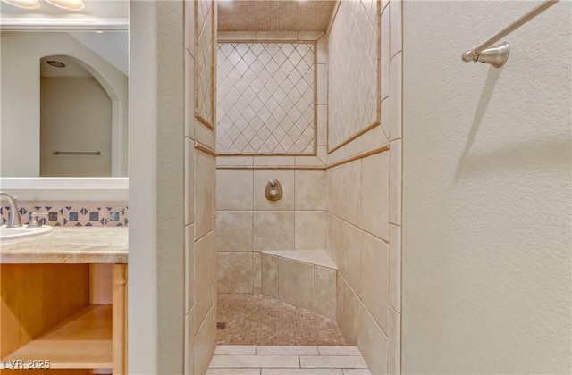 bathroom featuring vanity and tiled shower