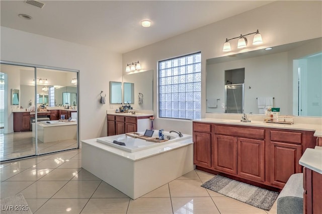 bathroom with vanity, tile patterned floors, and plus walk in shower