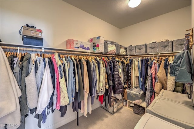 spacious closet with carpet flooring and independent washer and dryer