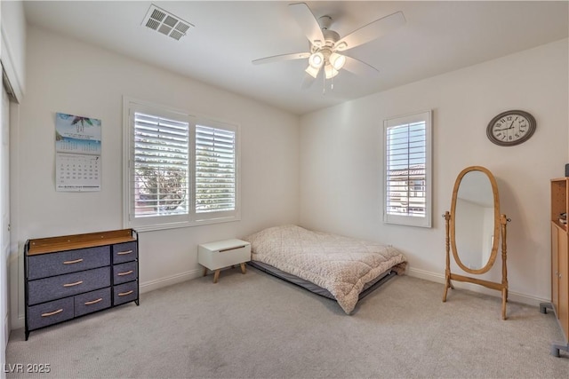 bedroom with multiple windows, light carpet, and ceiling fan