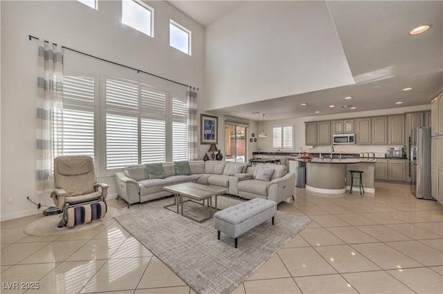 living room with light tile patterned floors, plenty of natural light, and a high ceiling