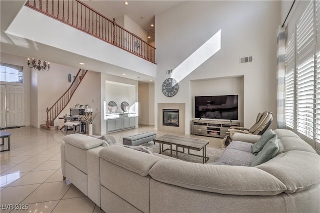 tiled living room with a towering ceiling and a notable chandelier