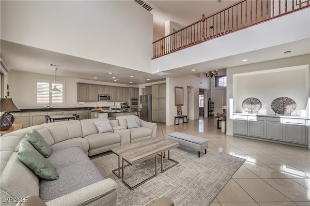 living room featuring a high ceiling, light tile patterned floors, and a notable chandelier