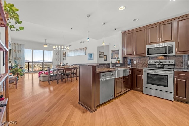 kitchen featuring pendant lighting, tasteful backsplash, sink, kitchen peninsula, and stainless steel appliances