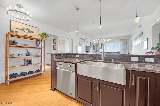 kitchen with pendant lighting, dark brown cabinetry, sink, and dark stone countertops