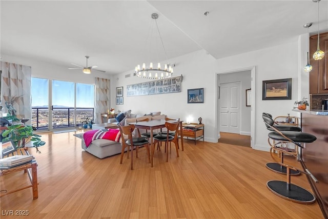 dining area with ceiling fan and light hardwood / wood-style floors