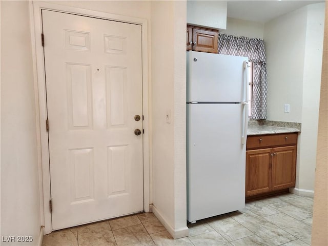 kitchen featuring white refrigerator and light tile patterned floors