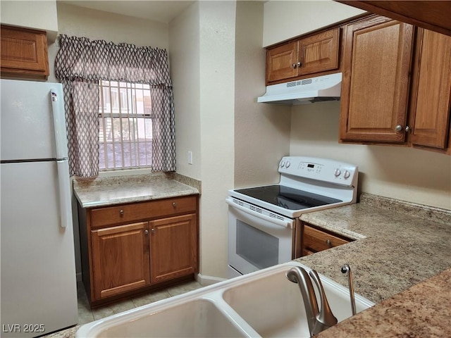 kitchen with sink, white appliances, and light stone countertops