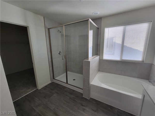 bathroom featuring hardwood / wood-style flooring and plus walk in shower