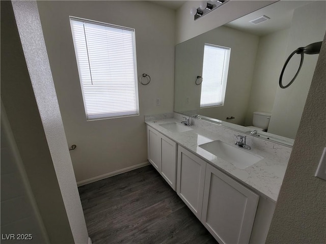 bathroom featuring vanity, wood-type flooring, a wealth of natural light, and toilet