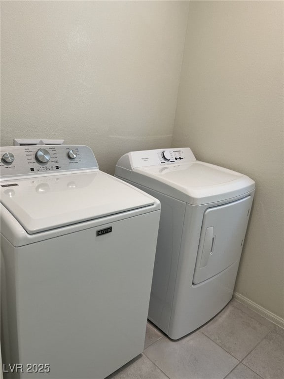 laundry room featuring light tile patterned floors and washing machine and clothes dryer