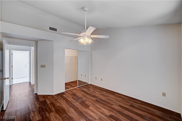 unfurnished bedroom featuring ceiling fan, dark hardwood / wood-style flooring, and a closet